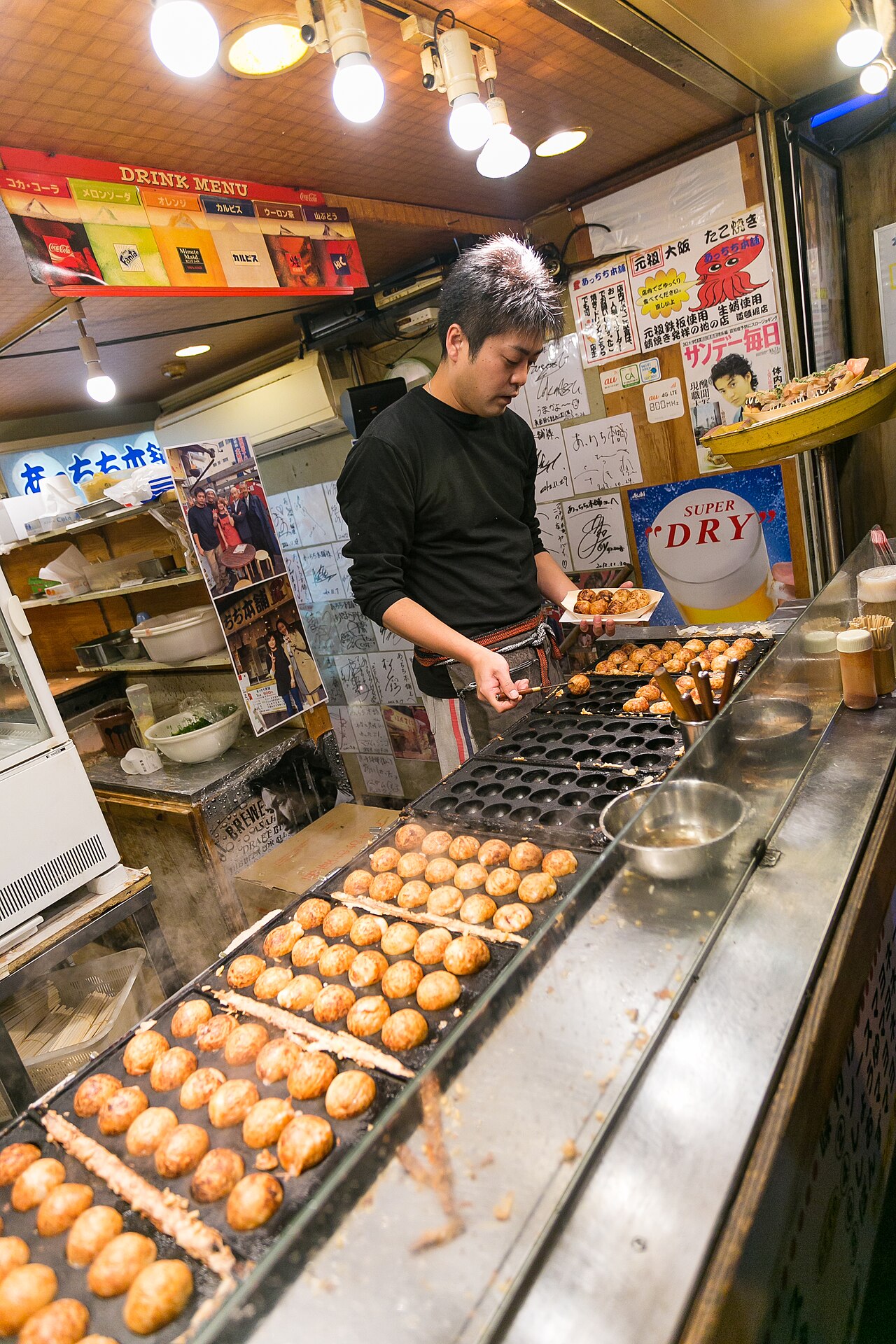 Takoyaki - Takoyaki being turned in hot cast-iron moulds at a stall in Osaka