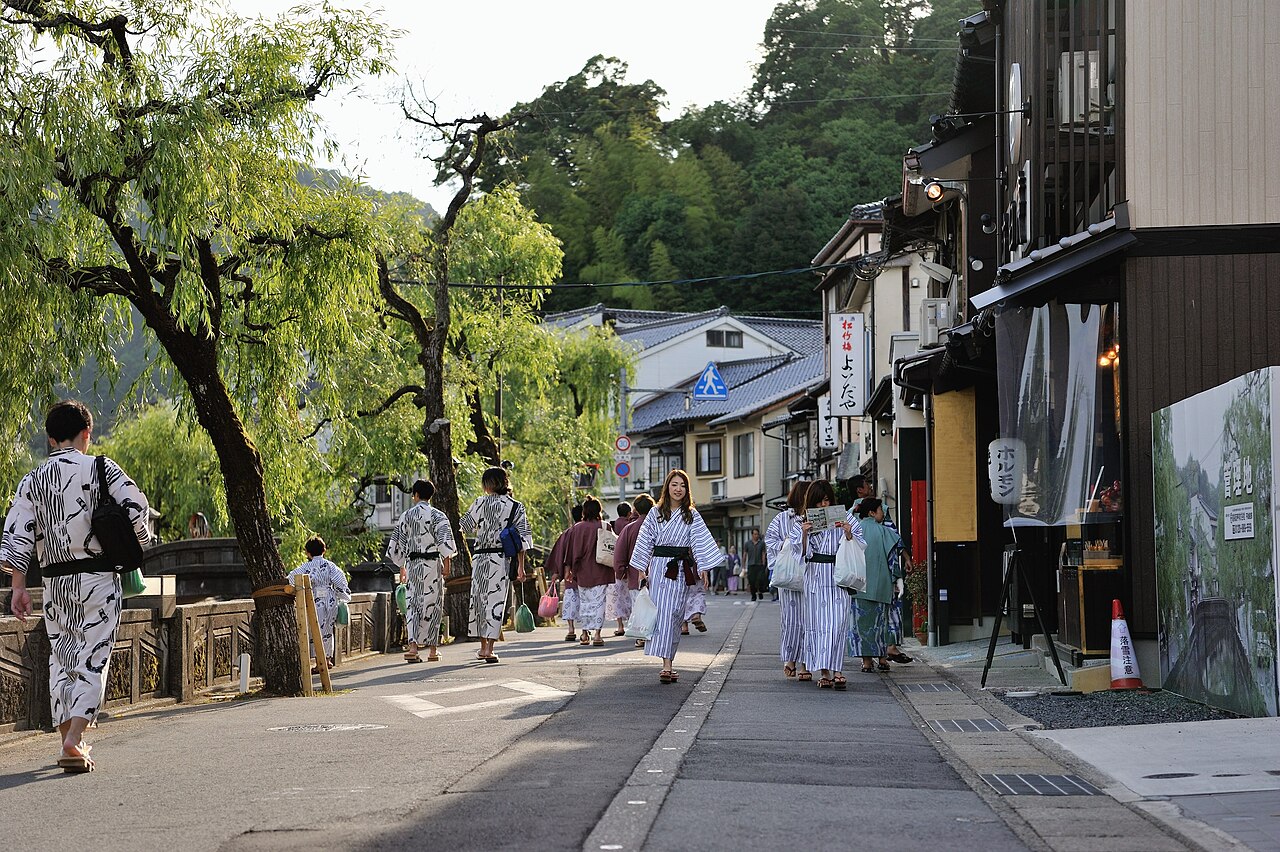 Kinosaki street - Visitors in matching ryokan yukata walking along the willow-lined canal
