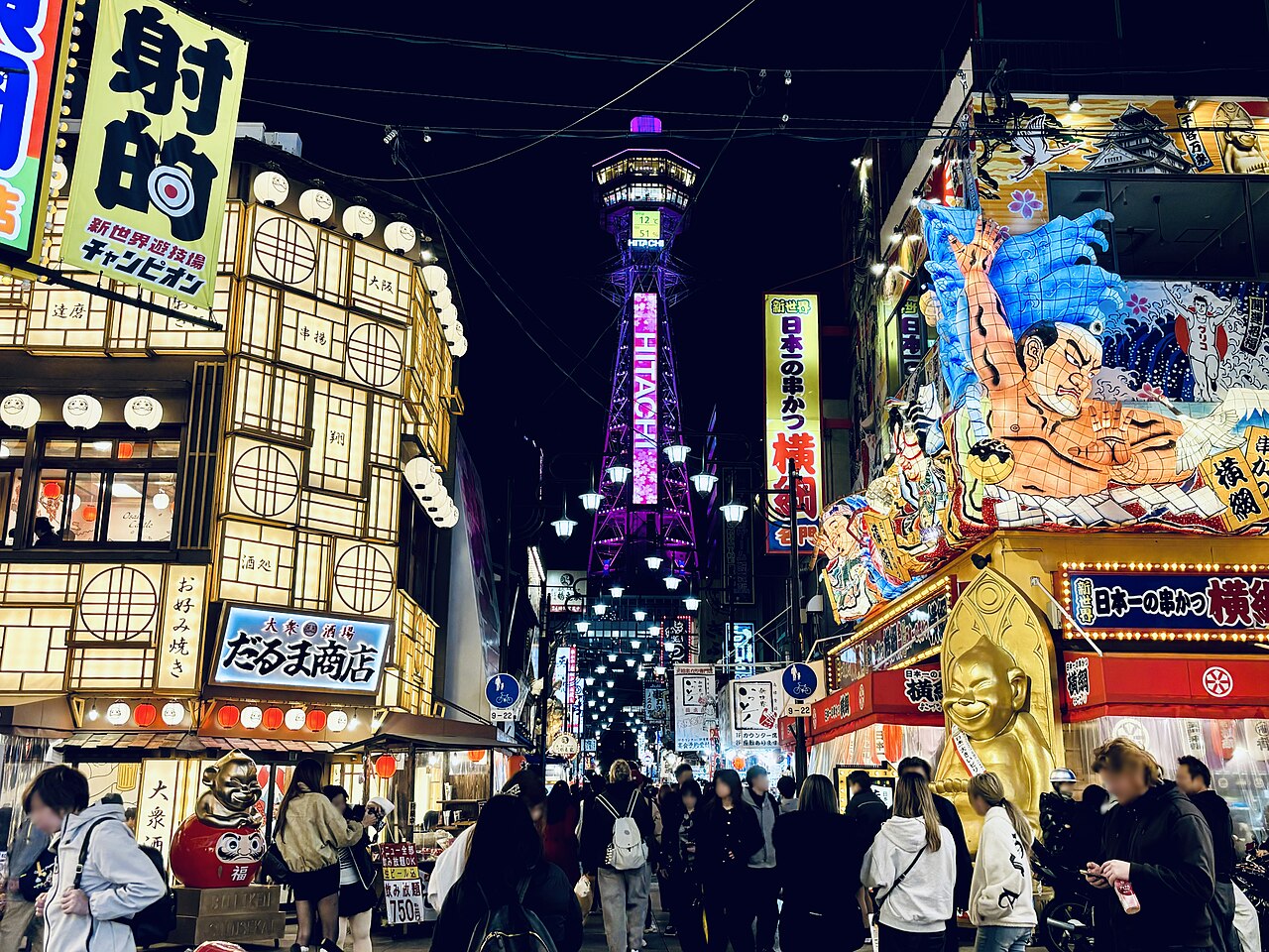 Shinsekai - Signs and lanterns along Shinsekai with Tsutenkaku Tower behind