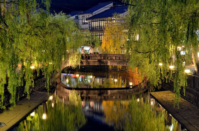 Kinosaki Onsen at night - Lantern-lit stone bridge over the Otani River framed by willow trees